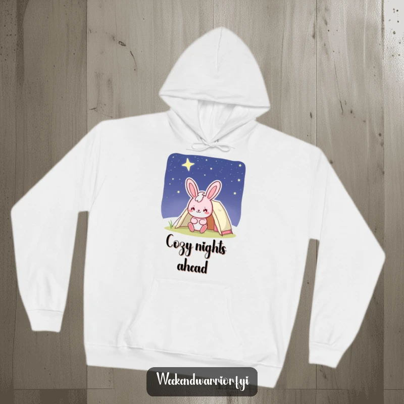 Funny bunny hoodie featuring a cheerful pink character with a confident smile setting up a tent under a starry sky, cozy and humorous.