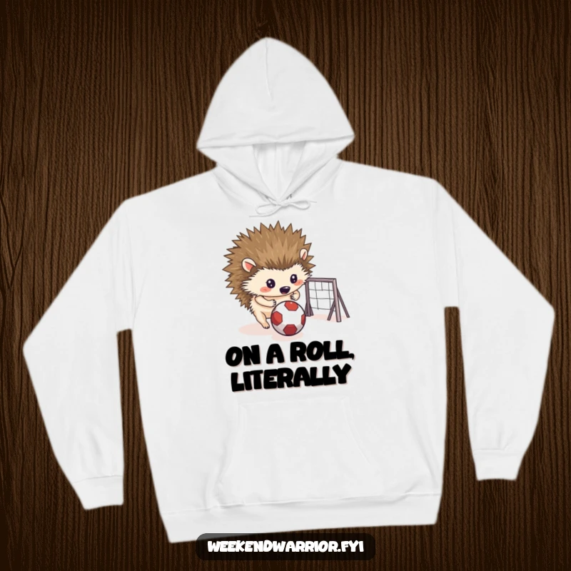 Funny hoodie graphic of a determined hedgehog intensely rolling a small ball towards a makeshift goal, showing concentration.