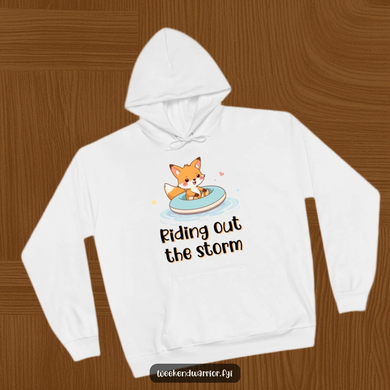 Funny fox raft hoodie featuring a cheerful fox sailing on an inflatable raft over a puddle, embodying playful exploration.