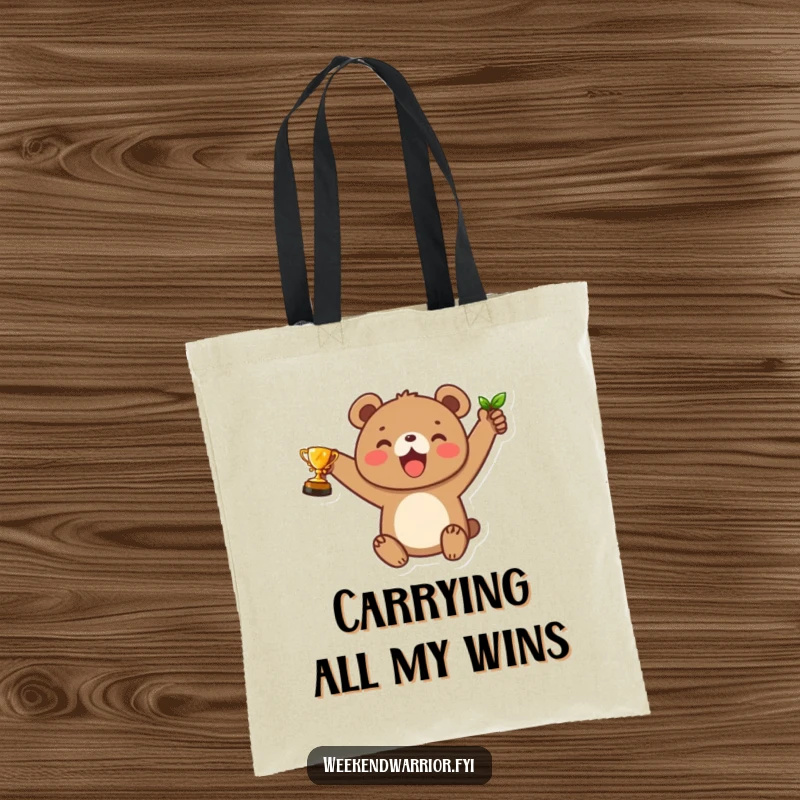 Funny tote bag featuring a joyful bear cub raising a small leaf trophy, a cheerful accessory for carrying daily wins.